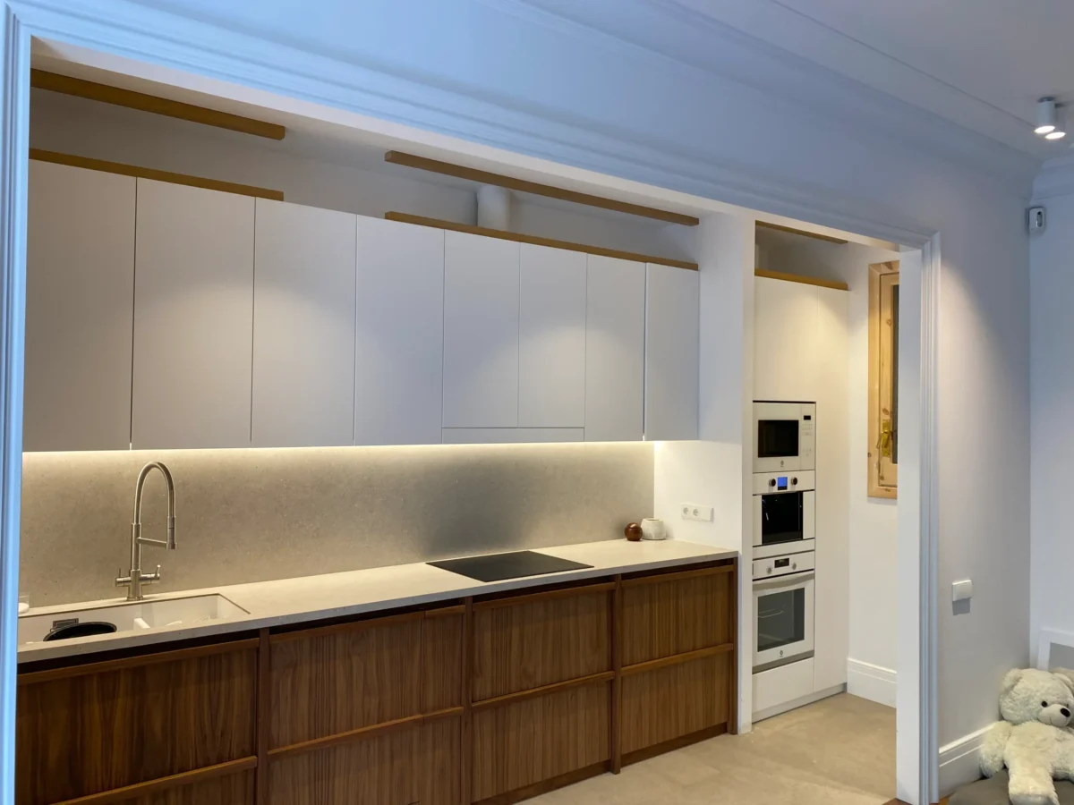 Cocina moderna con muebles de madera y electrodomésticos integrados.