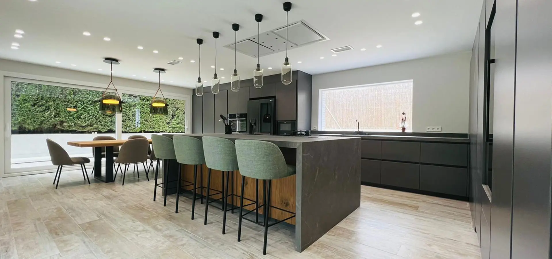 Cocina moderna reformada con isla central y comedor integrado.